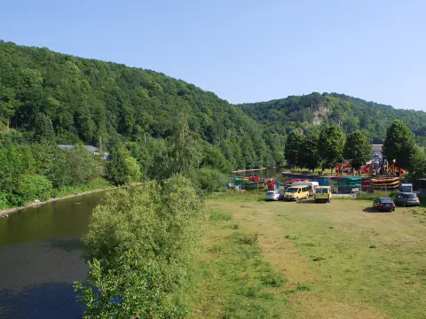 Kayaks et canoës posés sur la berge de l'Ourthe à Bomal, avant la mise à l'eau