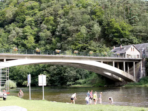 Le pont de Membre-sur-Semois au-dessus de la rivière, avec des baigneurs sur la rive