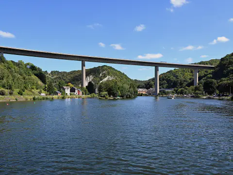 La Meuse à Dinant, large et calme, sous le viaduc Charlemagne et des collines boisées
